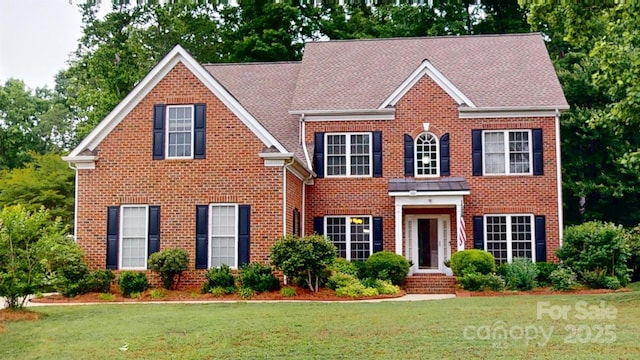 view of front of property with a front lawn and brick siding