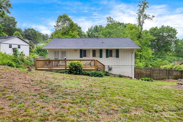 rear view of house featuring a wooden deck and roof with shingles