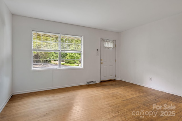 spare room with light wood finished floors and baseboards