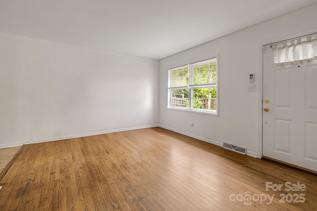 foyer entrance with wood finished floors and baseboards