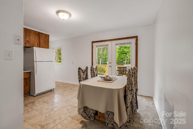 dining space with healthy amount of natural light, french doors, and baseboards