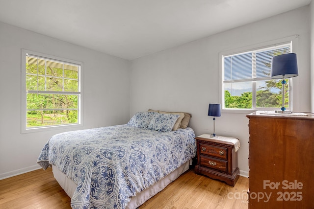 bedroom with light wood-style flooring and baseboards