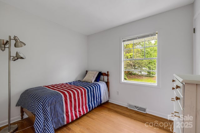 bedroom featuring baseboards and wood finished floors