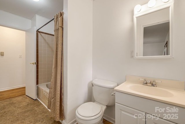 bathroom with toilet, vanity, shower / bath combo, and baseboards
