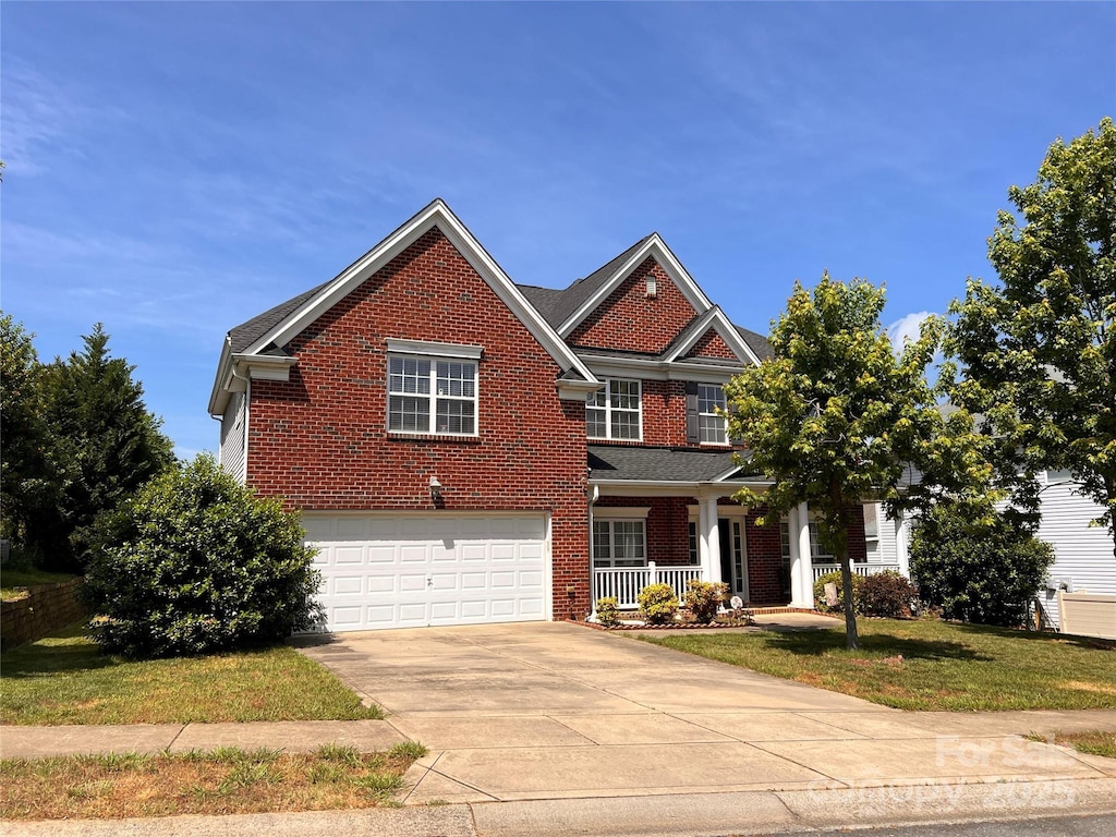 view of front facade featuring a porch, brick siding, a garage, concrete driveway, and a front lawn