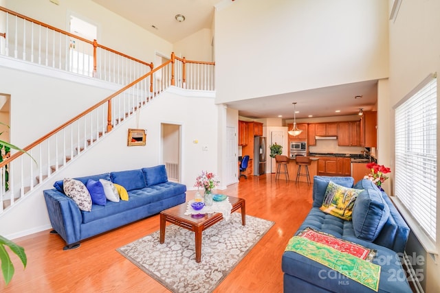 6227 Castlecove Rd, Charlotte, NC 28278 - living room with a high ceiling, light wood-type flooring, and stairway