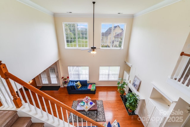 6227 Castlecove Rd, Charlotte, NC 28278 - living room featuring stairway, plenty of natural light, wood finished floors, a ceiling fan, and a high ceiling