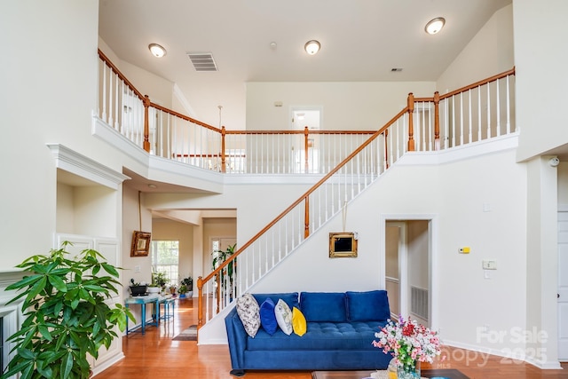 6227 Castlecove Rd, Charlotte, NC 28278 - living room featuring stairs, a high ceiling, and wood finished floors