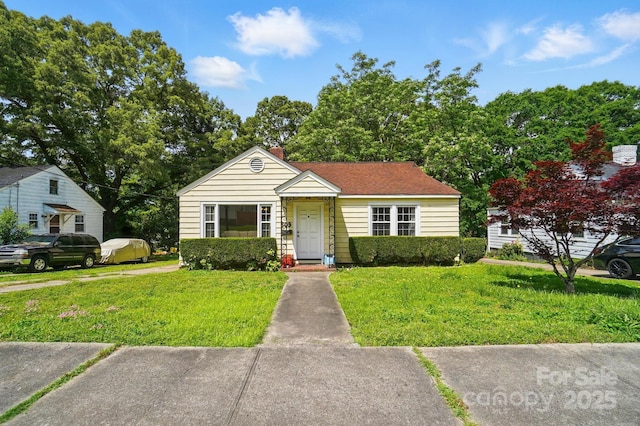 bungalow-style home featuring a front lawn and a chimney