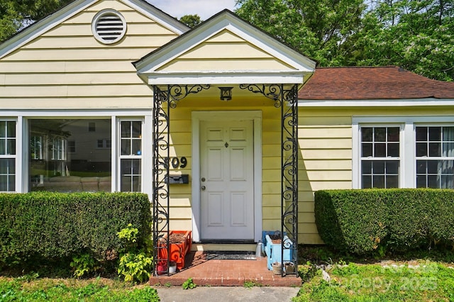 doorway to property featuring a shingled roof