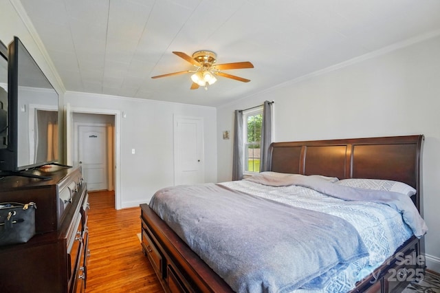 bedroom featuring wood finished floors, crown molding, ceiling fan, and baseboards