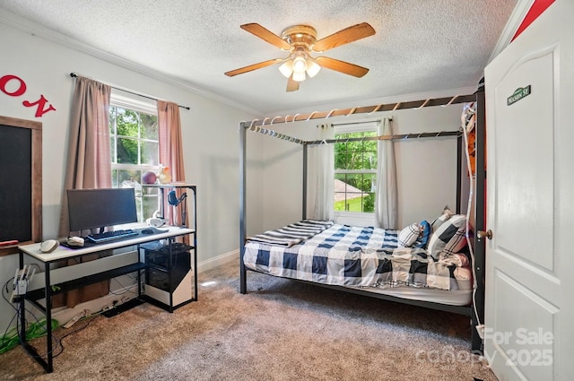carpeted bedroom with multiple windows, ornamental molding, a textured ceiling, ceiling fan, and an office area
