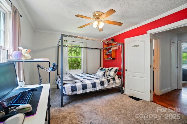 carpeted bedroom featuring crown molding, a textured ceiling, ceiling fan, and baseboards