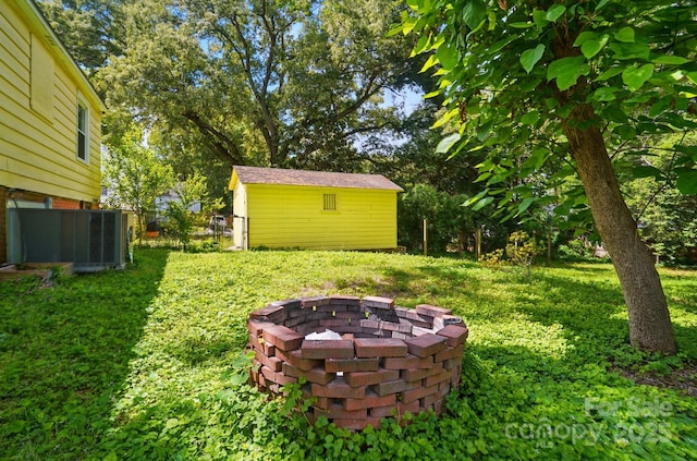 view of yard with a fire pit and an outdoor structure