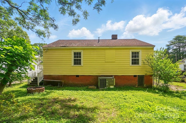 rear view of property with cooling unit and a chimney