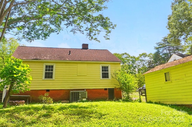 back of property with central AC and a chimney