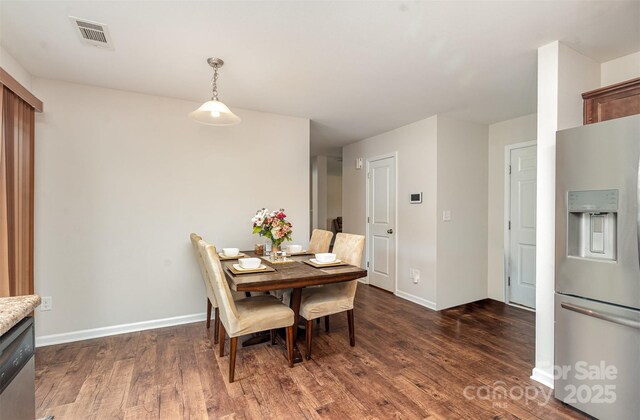dining room featuring dark wood-style flooring and baseboards