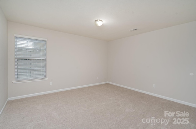 carpeted empty room with baseboards