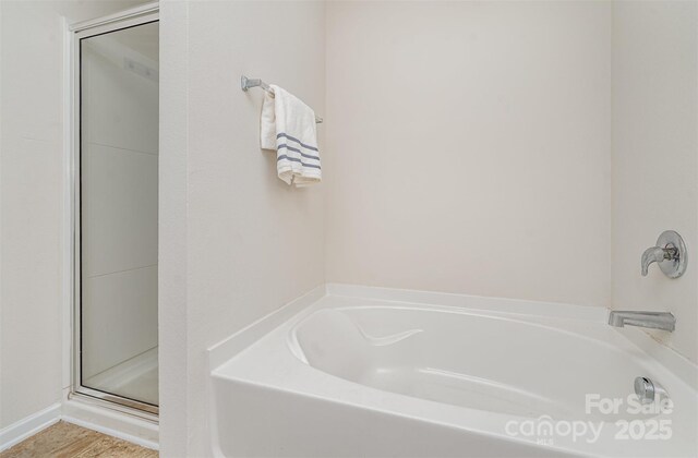 bathroom with a stall shower and a bath