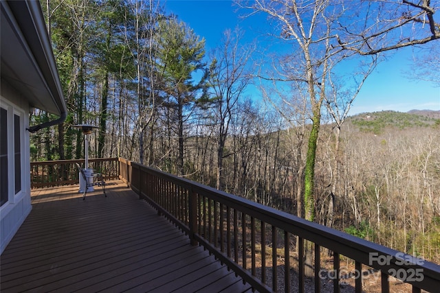 wooden terrace featuring a wooded view