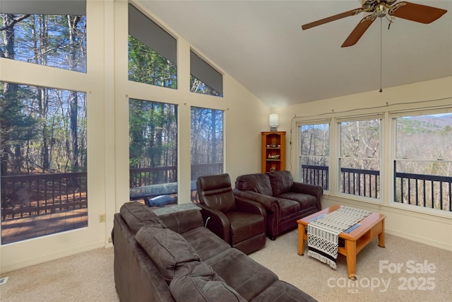 carpeted living room featuring high vaulted ceiling, ceiling fan, and baseboards