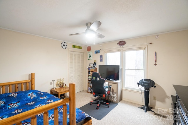bedroom featuring carpet, a closet, a ceiling fan, and crown molding