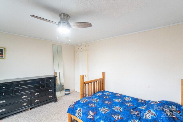 carpeted bedroom featuring ornamental molding and a ceiling fan