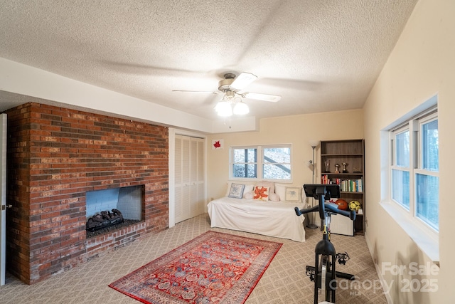 bedroom with carpet floors, a textured ceiling, a fireplace, and a ceiling fan