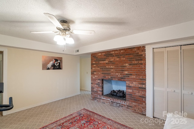 unfurnished living room featuring a fireplace, carpet floors, a ceiling fan, baseboards, and a textured ceiling