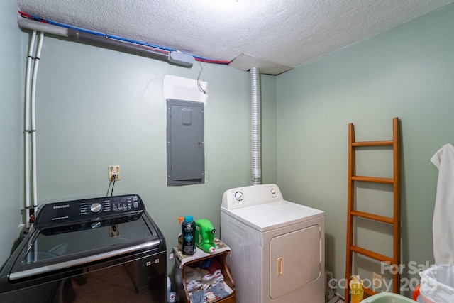 washroom with electric panel, washing machine and clothes dryer, and a textured ceiling