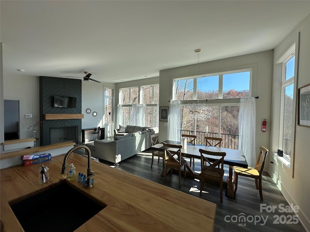 3149 Winter Hawk Ln, Lenoir, NC 28645 - dining room featuring a fireplace, plenty of natural light, dark wood-type flooring, and ceiling fan