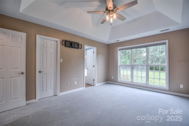 330 Kilmer Ln, Mooresville, NC 28115 - unfurnished bedroom featuring carpet, a tray ceiling, baseboards, connected bathroom, and ceiling fan