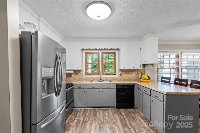603 Sunnybrook Dr, Monroe, NC 28110 - kitchen featuring appliances with stainless steel finishes, gray cabinets, a peninsula, a sink, and wood finished floors