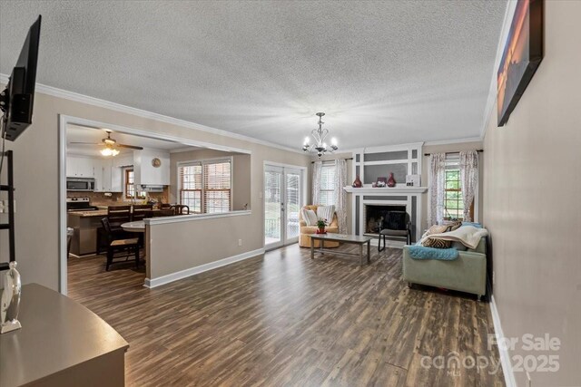 603 Sunnybrook Dr, Monroe, NC 28110 - living area with a textured ceiling, dark wood-style flooring, ornamental molding, a chandelier, and baseboards