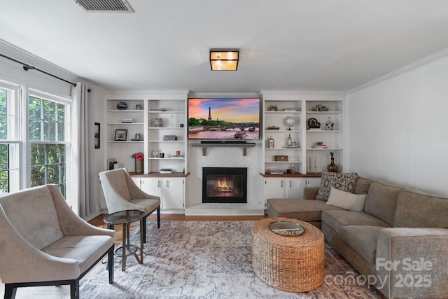 1014 Vandalia Dr, Charlotte, NC 28212 - living area featuring a glass covered fireplace, crown molding, wood finished floors, and built in shelves