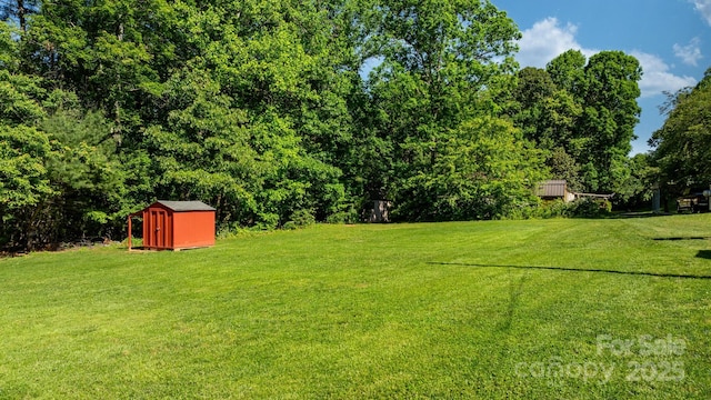 view of green lawn with a storage unit and an outdoor structure