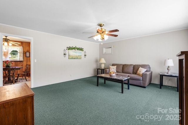 living area featuring ceiling fan, carpet flooring, and ornamental molding