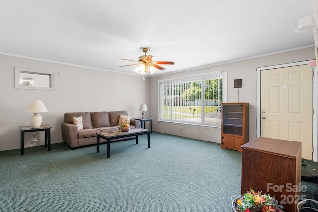 carpeted living area with ceiling fan and crown molding
