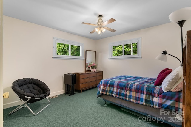 bedroom featuring multiple windows, baseboards, carpet floors, and ceiling fan