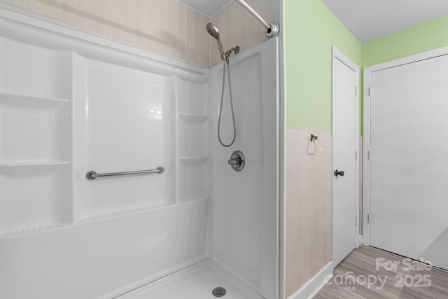 full bath featuring a shower and wood finished floors