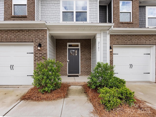 2141 Bexar Trl, Matthews, NC 28105 - property entrance with a garage, brick siding, driveway, and a porch