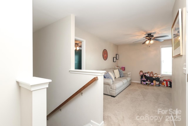 living room with a ceiling fan, carpet flooring, and baseboards