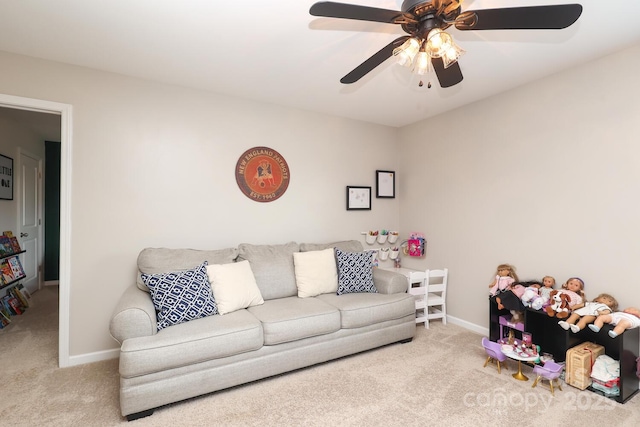carpeted living area with a ceiling fan and baseboards