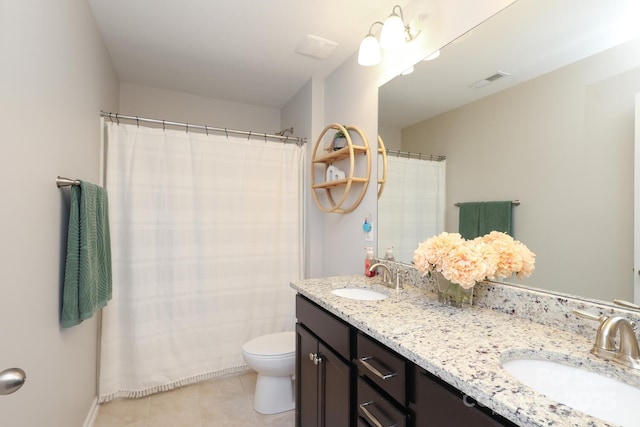 bathroom with tile patterned flooring, toilet, and double vanity