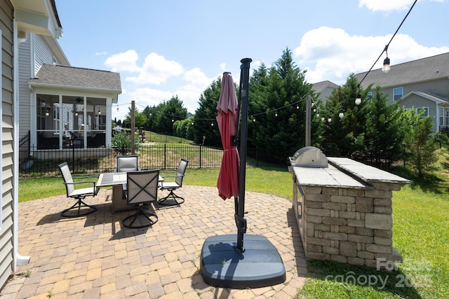 view of patio featuring an outdoor kitchen, a sunroom, and outdoor dining space