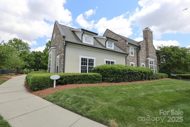 view of side of home with stone siding, a chimney, a lawn, and stucco siding