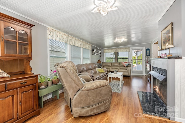 125 Maple St, New London, NC 28127 - living room with a fireplace with flush hearth, ornamental molding, light wood-style floors, and a chandelier