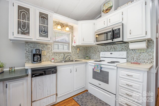 125 Maple St, New London, NC 28127 - kitchen with dishwasher, white range with electric cooktop, stainless steel microwave, a sink, and white cabinetry