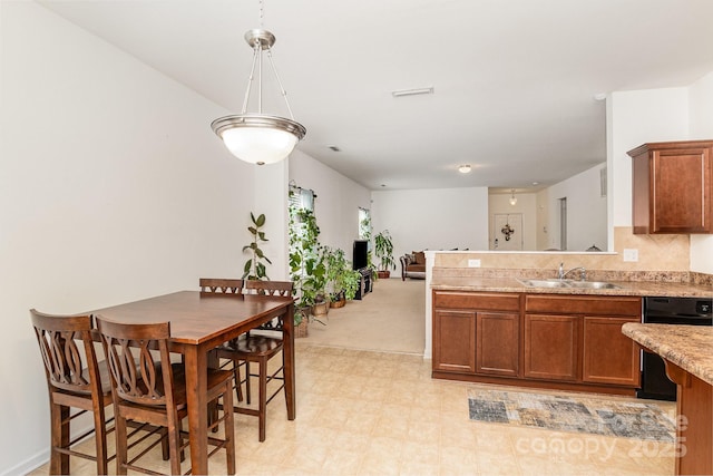 12792 Clydesdale Dr, Midland, NC 28107 - kitchen featuring black dishwasher, brown cabinets, a sink, light countertops, and a peninsula