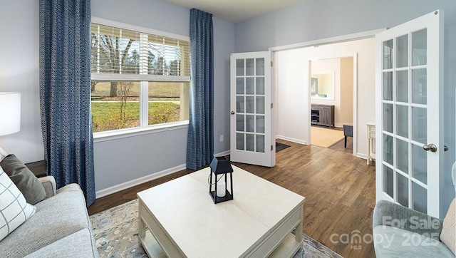 living room with french doors, wood finished floors, and baseboards